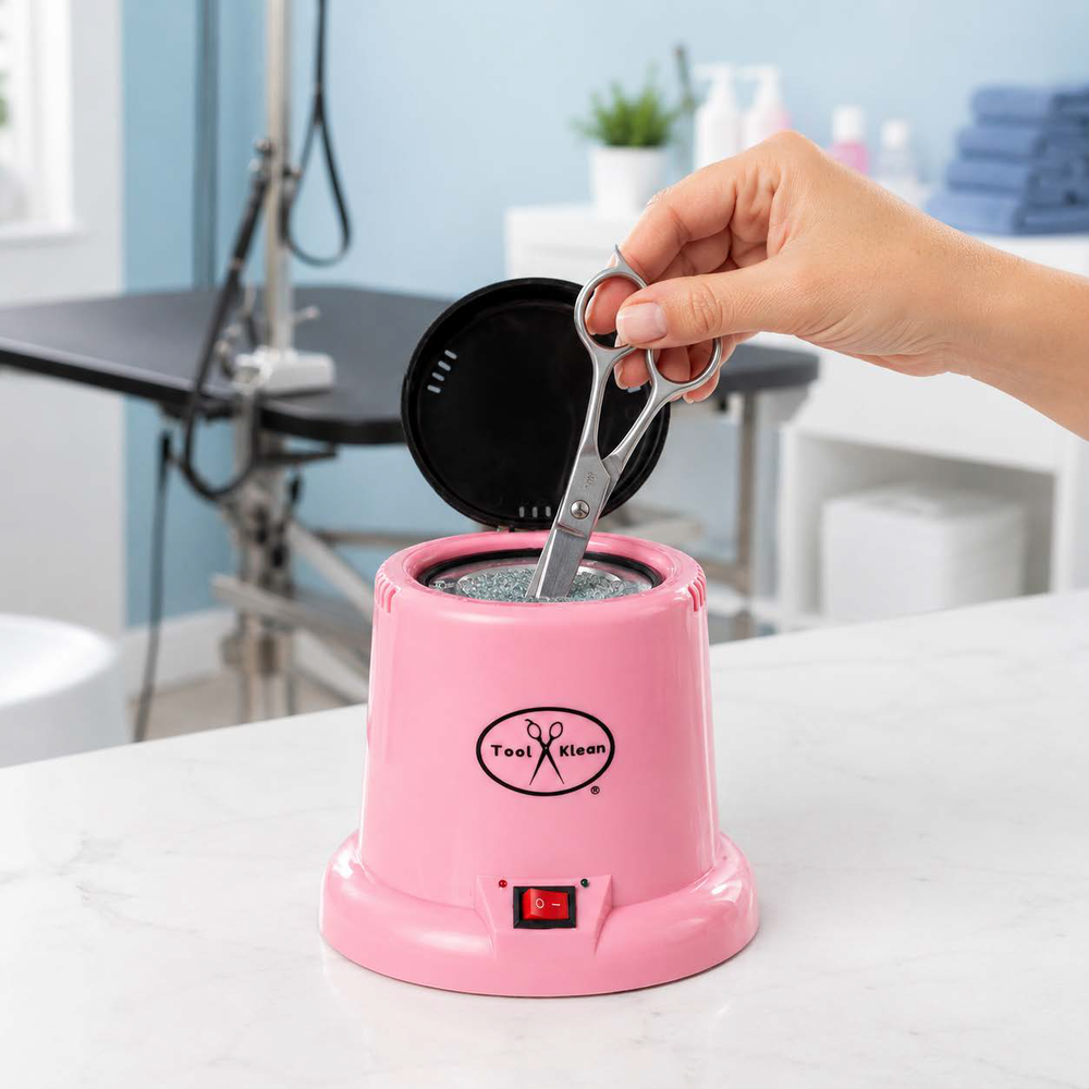 Groomer placing scissor blades into the Pink Hot Cup sanitizer